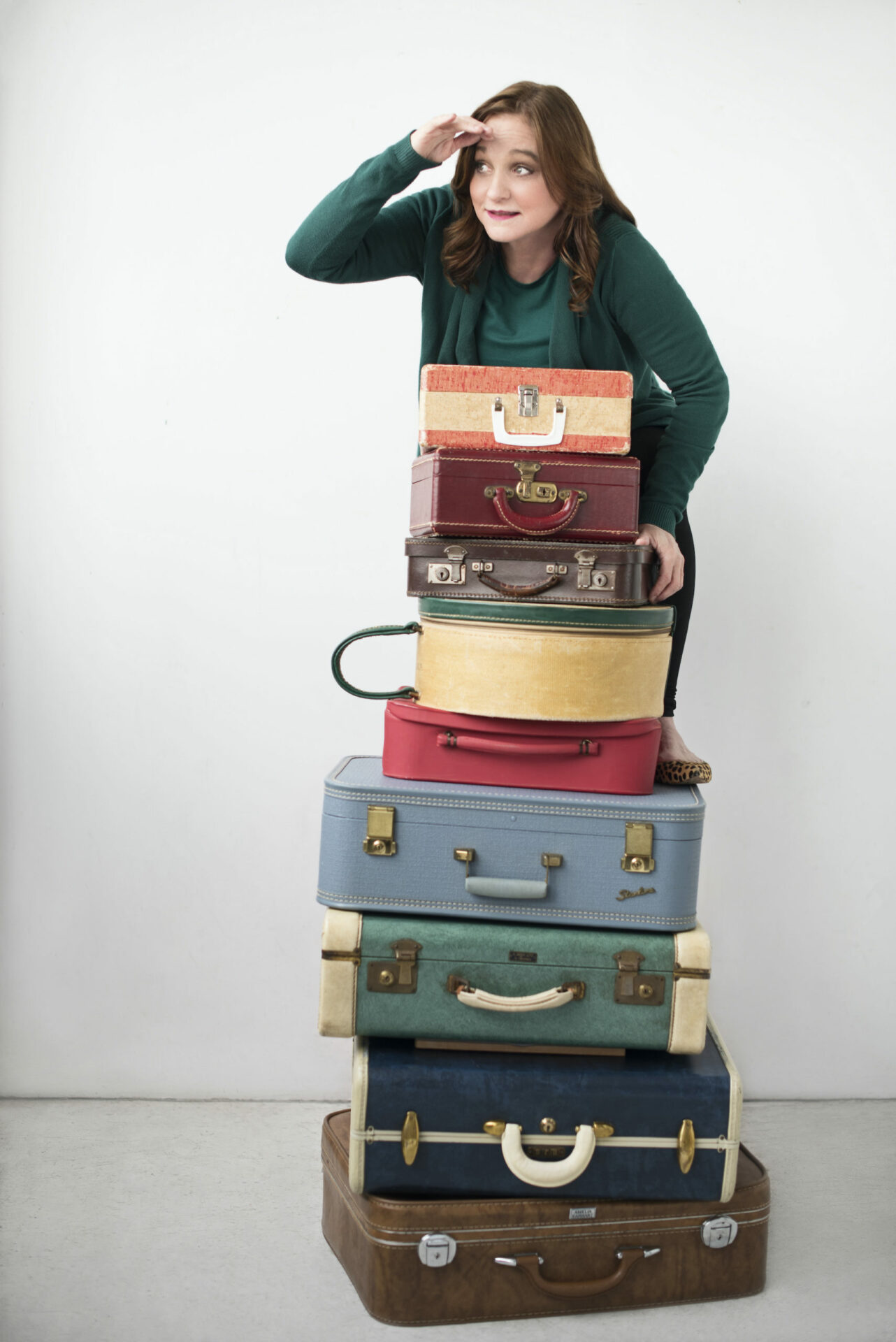 Stack of suitcases with Lori Hamiton peering over it